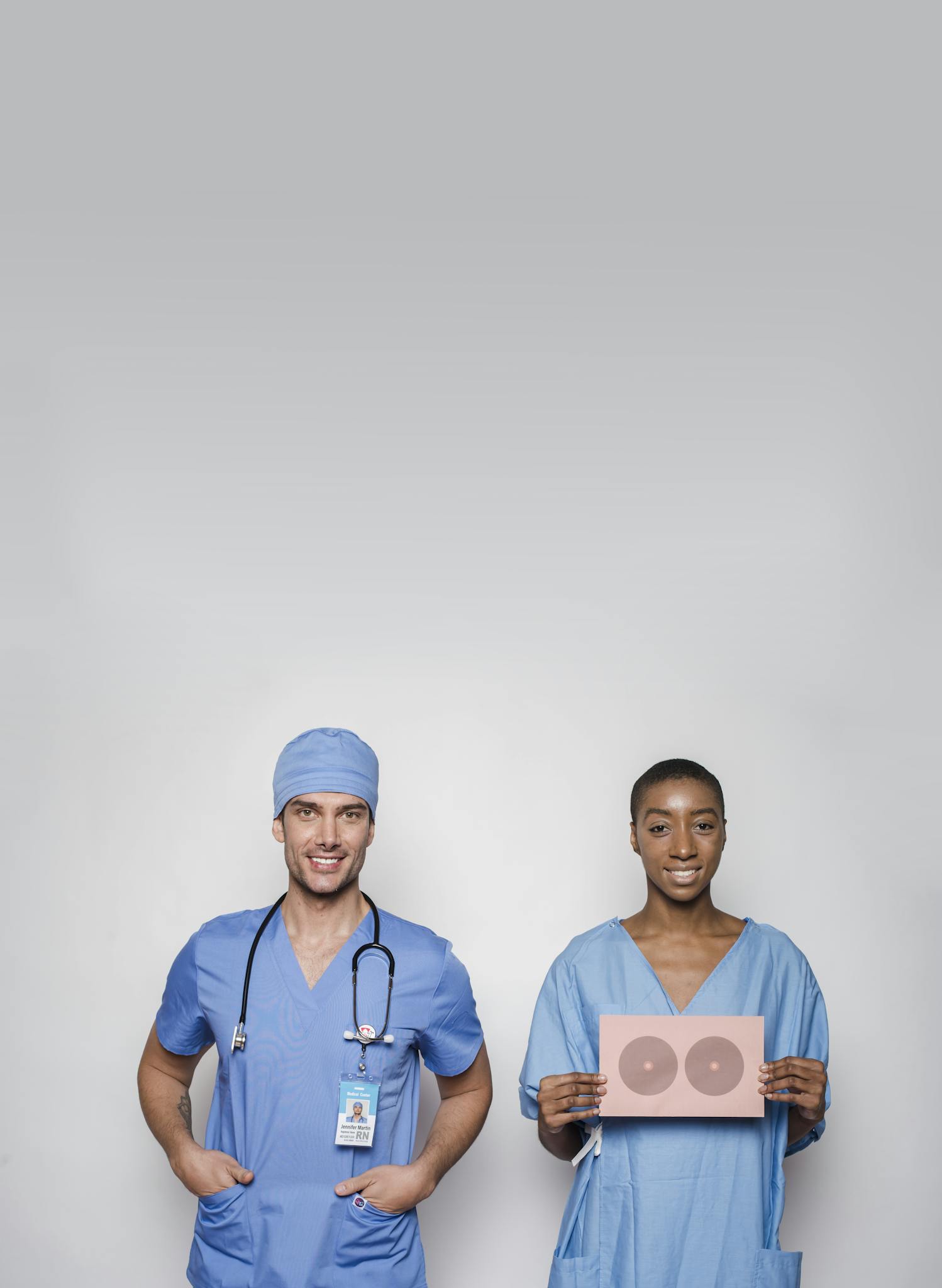 Two medical professionals promoting breast cancer awareness and healthcare solidarity.